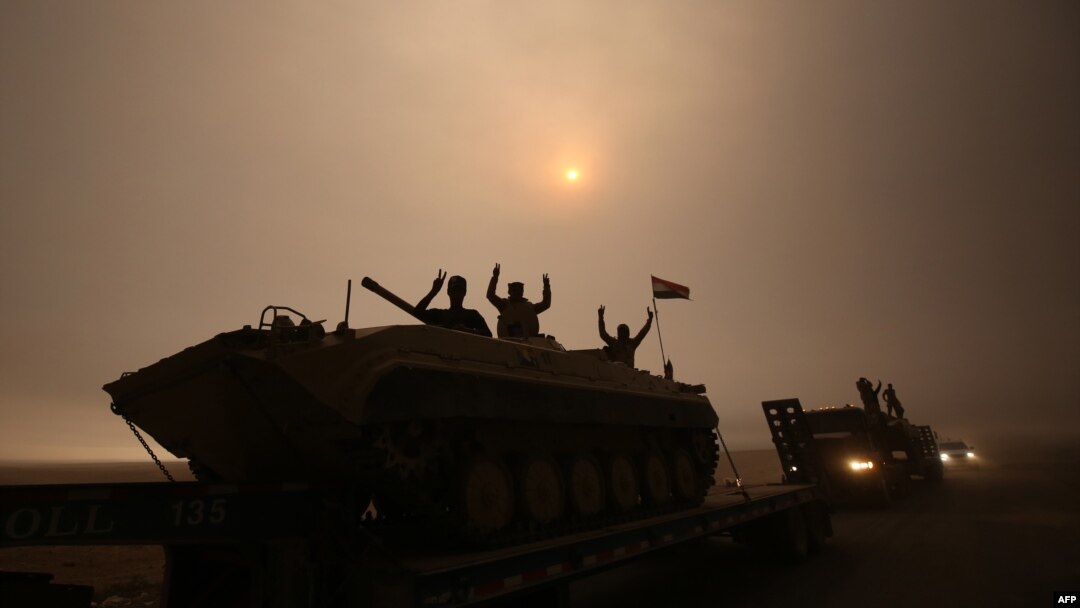 Tentara Irak mengacungkan dua jari tanda kemenangan saat berkendara melewati daerah al-Shura, arah selatan Mosul (24/10). (AFP/Ahmad al-Rubaye)