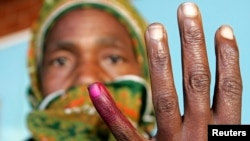 A woman shows her ink-stained finger after casting her vote in Zimbabwe's presidential and parliamentary elections in the capital Harare March 29, 2008. REUTERS/Howard Burditt (ZIMBABWE) - GM1E43T1E9U01 