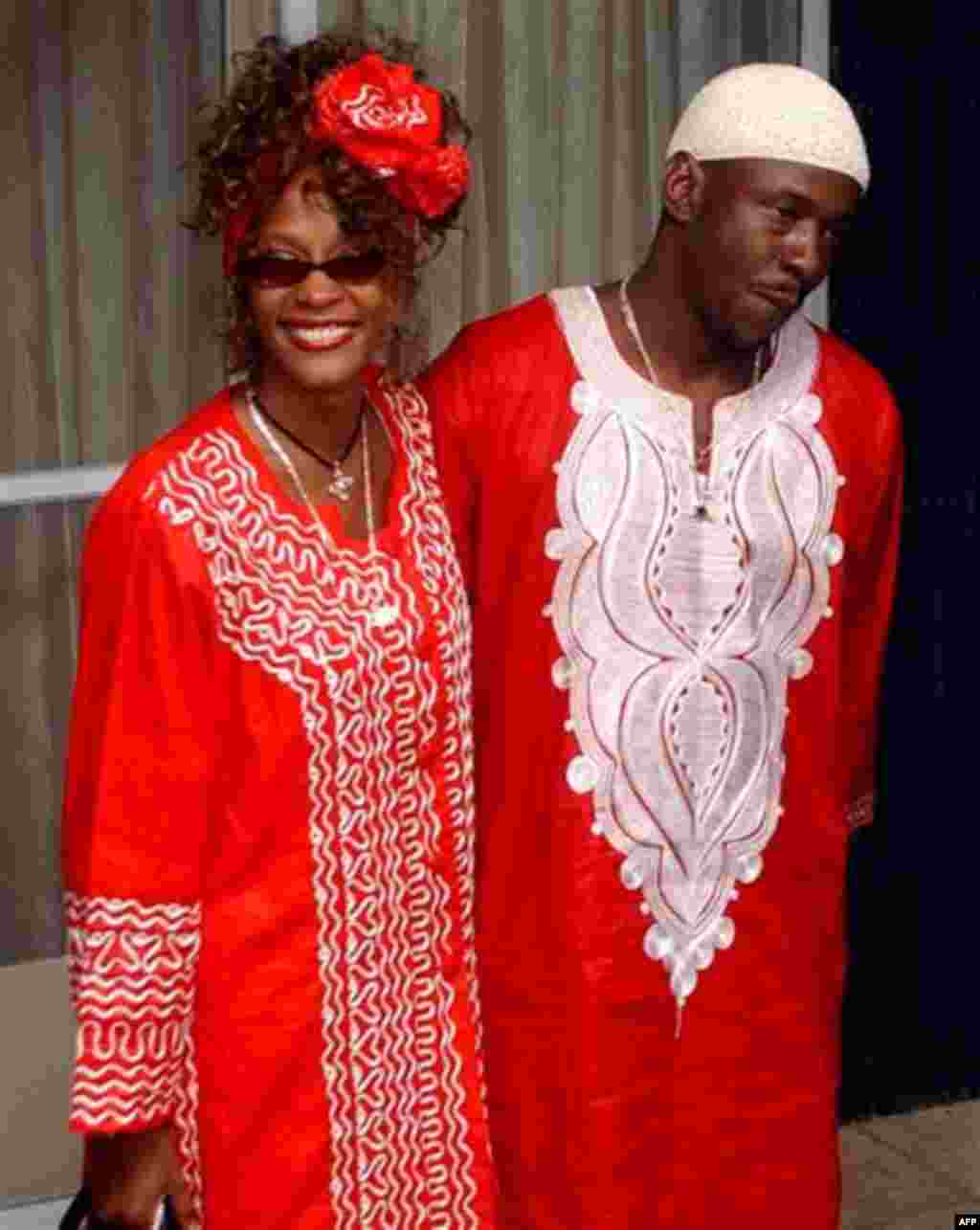 ** FILE ** Singer Whitney Houston smiles next to her husband Bobby Brown during a visit to Jerusalem, on May 27, 2003. Houston has filed for divorce from Brown, her publicist told The Associated Press on Wednesday, Sept. 13, 2006. (AP Photo/Pier Paolo C