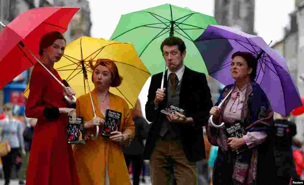 Performers hand out flyers on the The Royal Mile trying to attract people to their show, in Edinburgh, Scotland.