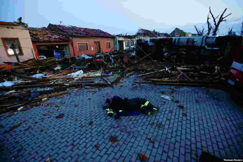 체코 모라브스카 노바 베스에 토네이도가 지나가면서 붕괴된 주택 주변에서 구조대원들이 휴식을 취하고 있다.