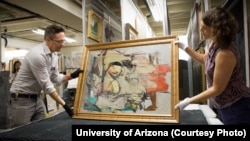 University of Arizona staff members prepare to examine Willem de Kooning's work after it was returned to the school.