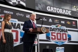 President Donald Trump, accompanied by first lady Melania Trump, speaks before the start of the NASCAR Daytona 500 auto race at Daytona International Speedway, Feb. 16, 2020, in Daytona Beach, Fla.