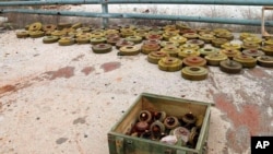 In this photo released by the Syrian official news agency SANA, landmines are collected by Syrian engineering troops from the M5 highway, recaptured by President Bashar Assad's forces this week, in Aleppo, Syria, Feb. 15, 2020.