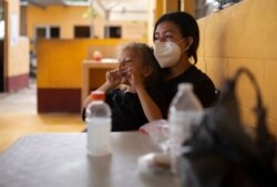 Una migrante hondureña carga a su hija de 5 años en un albergue de la Casa del Migrante en El Ceibo, Guatemala, el 12 de agosto de 2021.