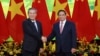 Perdana Menteri China Li Qiang, kiri, dan Perdana Menteri Vietnam Pham Minh Chinh berjabat tangan sebelum pertemuan di Hanoi, 13 Oktober 2024. (Duong Van Giang/VNA via AP)