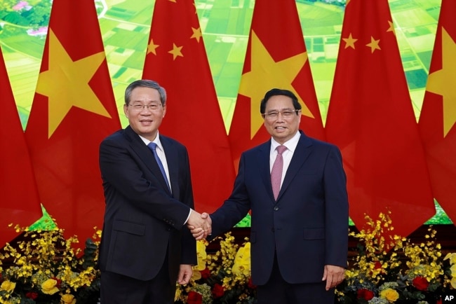 Chinese Premier Li Qiang, left, and Vietnamese Prime Minister Pham Minh Chinh shake hands before a meeting in Hanoi, Oct. 13, 2024. (Duong Van Giang/VNA via AP)