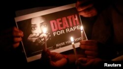 FILE - People hold a placard during a candlelight vigil in support of women safety in Mumbai, Dec. 20, 2012. India's Supreme Court upholds, July 9, 2018, the death penalty handed out to three men convicted of the 2012 gang rape and murder of a physiotherapy student. 