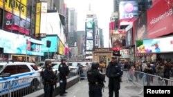 Polisi New York berjaga dengan senapan mesin di Times Square, New York (27/12).