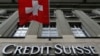 Logo bank milik Swiss, Credit Suisse, tampak di bawah bendera Swiss di sebuah gedung yang terletak di Federal Square di Bern, 15 May 2014 (foto: Reuters/Ruben Sprich)