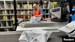 FILE - A person works at the Amazon warehouse, busy on Prime Day, in Melville, New York, July 11, 2023.