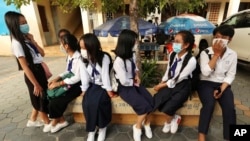 Students wearing face-masks, wait for their morning school class at Santhormok high school, in Phnom Penh, Cambodia, Monday, Nov. 2, 2020. (AP Photo/Heng Sinith)