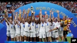 US team celebrates with trophy after winning the Women's World Cup final soccer match between US and The Netherlands at the Stade de Lyon in Decines, outside Lyon, France, July 7, 2019.