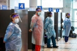 Trabajadores de salud se preparan para tomar la prueba del coronavirus a los pasajeros que llegan al aeropuerto Pearson de Toronto. La prueba es obligatoria pra llegadas internacionales en Mississauga, Ontario, Canada. Febrero 1, 2021.