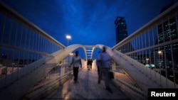 Workers cross the pedestrian bridge during rush hour from Bahrain Financial Harbour to downtown Manama, during the early evening hours in Manama, Bahrain, Nov.12, 2018.