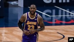 El jugador de los Lakers de Los Ángeles LeBron James (con el 23) celebra una canasta contra los Pelicans de Nueva Orleans, en Nueva Orleans, el domingo 16 de mayo de 2021. (AP Foto/Derick Hingle)