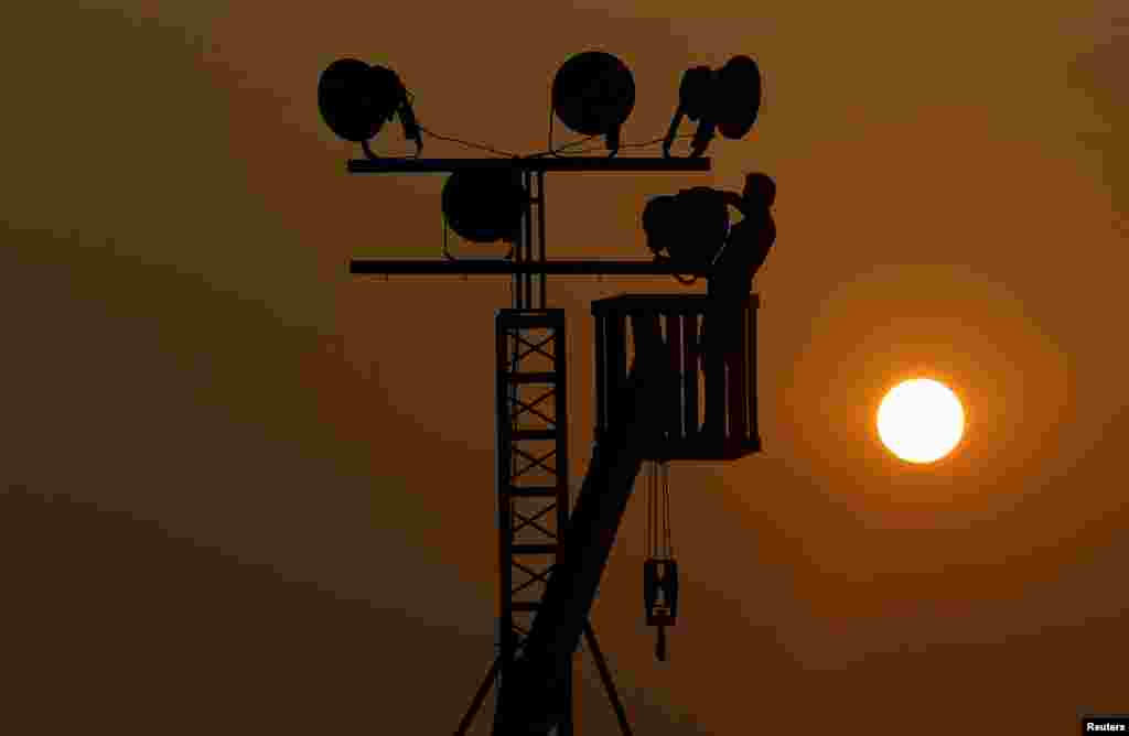 A man removes light bulbs on a temporary lamp post in Colombo, Sri Lanka.