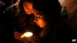 People light a candle for former president Nelson Mandela on hearing of his death outside his home in Johannesburg, South Africa, Dec. 5, 2013.