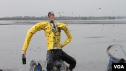 Ogoh-Ogoh Aburizal Bakrie Dilarung di Kolam Penampungan Lumpur Segabai Simbol Penyebab Bencana Kemanusiaan di Porong, Sidoarjo. (VOA/Petrus Riski)