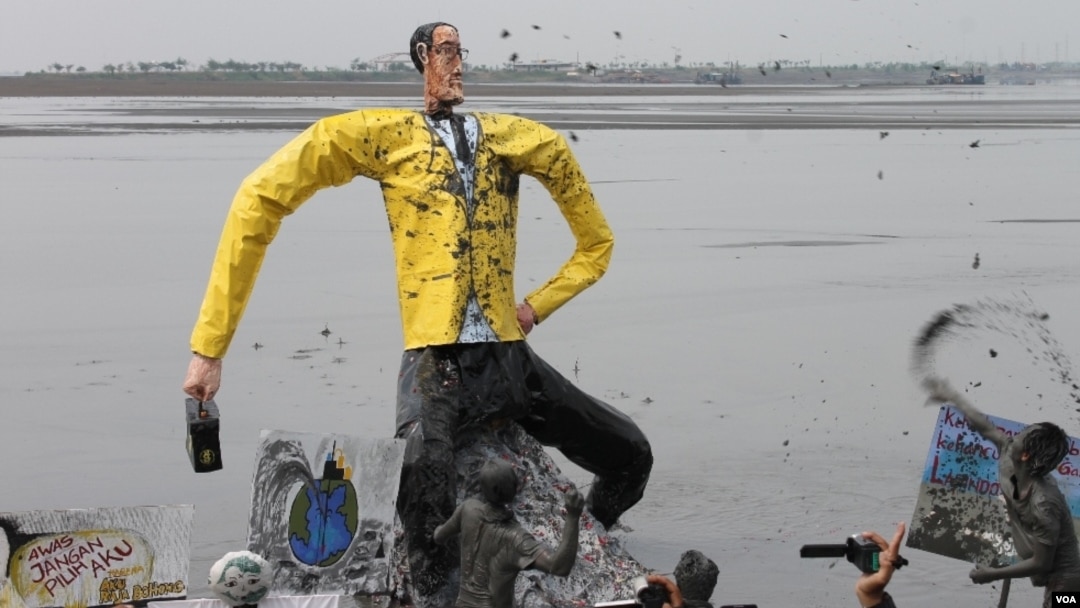 Ogoh-ogoh Aburizal Bakrie dilarung di kolam penampungan lumpur sebagai simbol penyebab bencana kemanusiaan di Porong, Sidoarjo. (VOA/Petrus Riski)