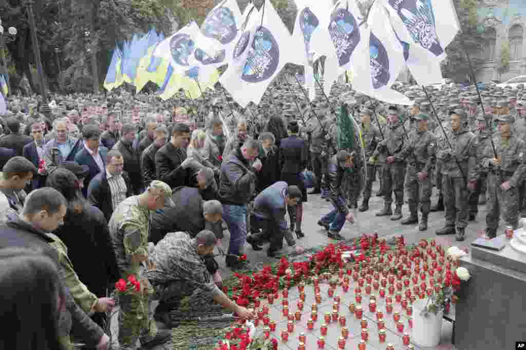 Ribuan tentara dan masyarakat sipil Ukraina meletakkan bunga di depan gedung parlemen di Kyiv di mana tiga tentara tewas pada 31 Agustus. Polisi mengatakan 141 orang terluka ketika protes nasionalis berubah menjadi kekerasan, dengan 10 orang yang terluka parah.