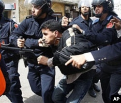 Moroccan police officers arrest a demonstrator during a protest against government policy in Casablanca, March 13, 2011