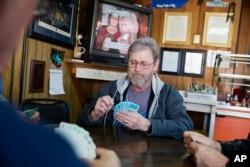 Wes Lewis plays cards with fellow regulars at the Frosty Freeze restaurant in Sandy Hook, Ky., Dec. 13, 2017.