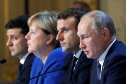 Ukraine's President Volodymyr Zelenskiy, German Chancellor Angela Merkel, French President Emmanuel Macron and Russia's President Vladimir Putin attend a joint news conference after a summit in Paris, Dec. 9, 2019.