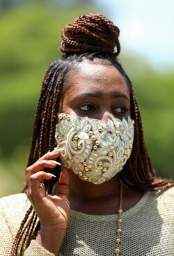Penata busana Nigeria Sefiya Diejomoah, 35, berpose untuk berfoto dengan masker yang serasi dengan pakaiannya, di Lagos, Nigeria 14 Mei 2020. (Foto: REUTERS/Temilade Adelaja)