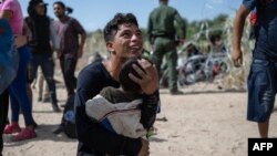 Una familia migrante venezolana reacciona luego de cruzar una barricada hacia suelo estadounidense en Eagle Pass, Texas, el 25 de septiembre de 2023. Miles de migrantes venezolanos han sido deportados desde Estados Unidos.