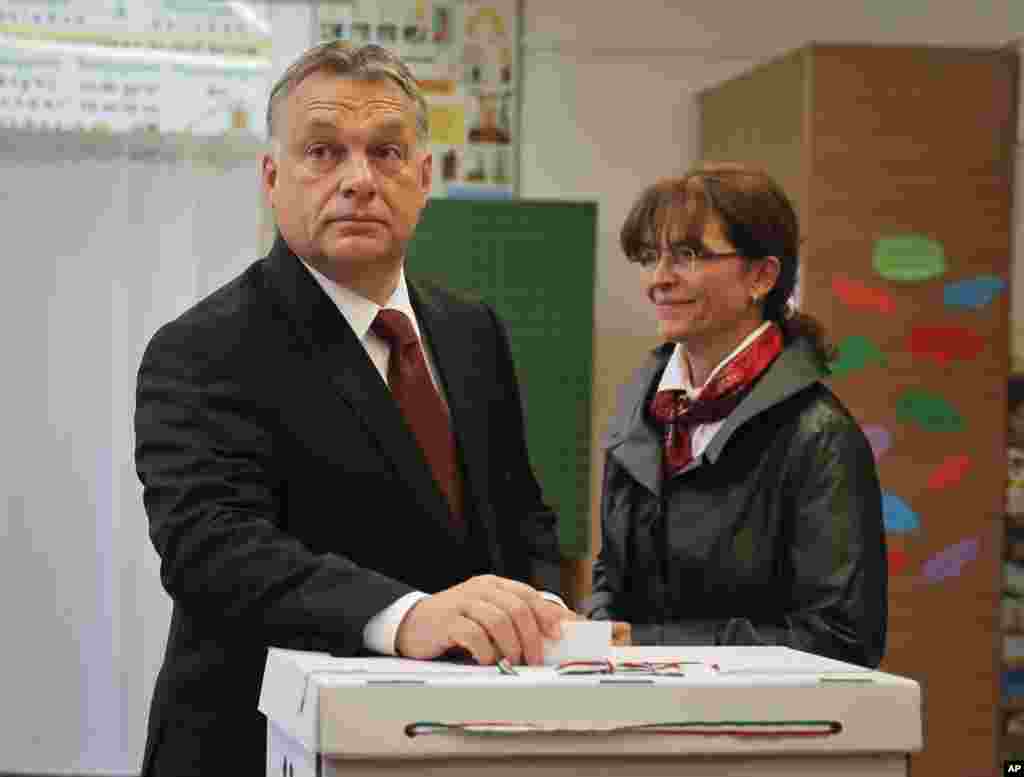 Hungarian Prime Minister Viktor Orban casts his vote in the referendum as his wife Aniko Levai stands by in Budapest, Oct. 2, 2016.