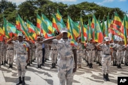 Anggota Angkatan Pertahanan Nasional Ethiopia memegang bendera nasional saat parade dalam upacara untuk mengenang para prajurit yang tewas pada hari pertama konflik Tigray, di luar kantor administrasi kota di Addis Ababa, Ethiopia, Kamis, 3 November 2022. (AP)