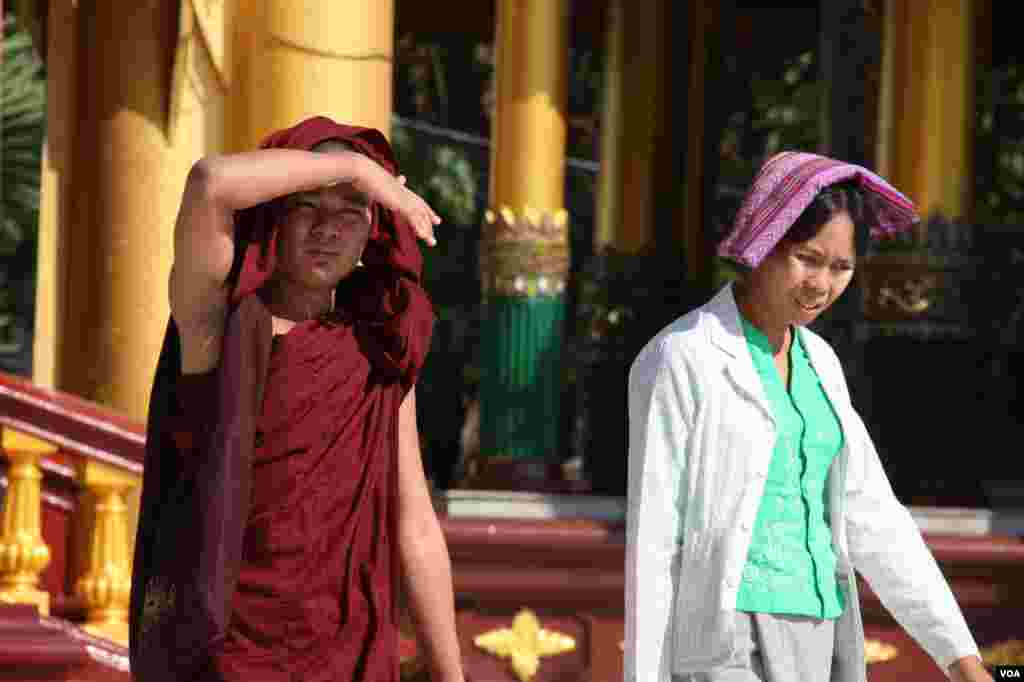 A monk blocks his face from the sun, Shwedegon Pagoda, Rangoon, Burma, November 22, 2012. (D. Schearf/VOA)