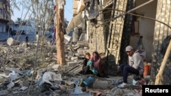 Palestinos fueron fotografiados mientras permanecían sentados entre escombros de una casa después de un ataque israelí, en medio del conflicto entre Israel y Hamás, en Nuseirat, en la Franja de Gaza central, el 1 de diciembre de 2024.