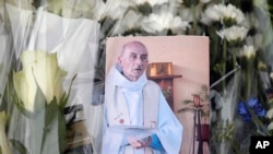 A picture of late Father Jacques Hamel is placed on flowers at the makeshift memorial in front of the city hall closed to the church where an hostage taking left a priest dead the day before in Saint-Etienne-du-Rouvray, Normandy, France, July 27, 2016. 