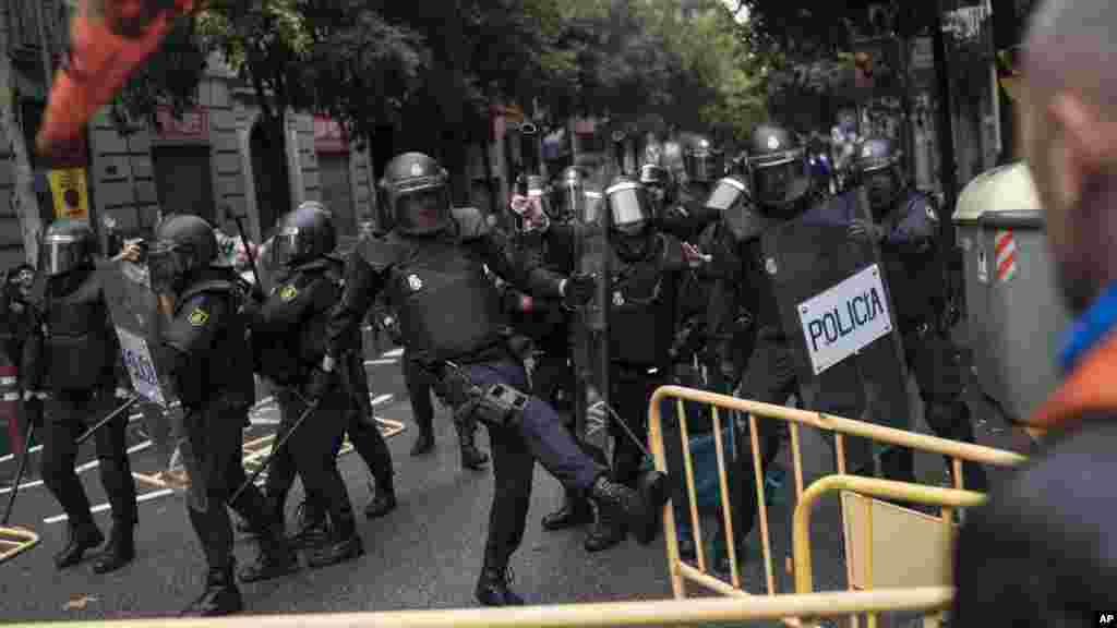 Des policiers enlèvent des barricades devant un bureau de voteà Barcelone, en Espagne, le 1er octobre 2017.