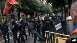 Police anti-émeutes devant un bureau de vote à Barcelone, en Espagne, le dimanche 1er octobre 2017.