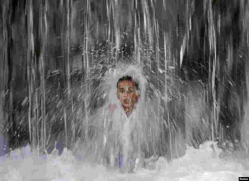 A boy cools off under a waterfall in Kabul, Afghanistan.