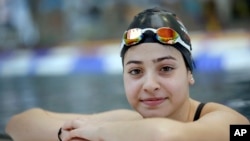 FILE - A Nov. 9, 2015 photo shows Yusra Mardini from Syria posing during a training session in Berlin, Germany. Mardini's family fled war and violence, crossing treacherous seas in small dinghies to live in dusty refugee camps.