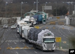 FILE - South Korean vehicles returning from North Korea's joint Kaesong Industrial Complex pass the customs, immigration and quarantine office near the border village of Panmunjom, in Paju, South Korea, Feb. 11, 2016.