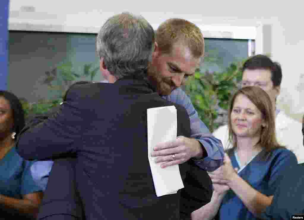 Kevin Brantly, who contracted the deadly Ebola virus, hugs a member of Emory&#39;s medical staff during a press conference at Emory University Hospital in Atlanta, Georgia, Aug. 21, 2014.