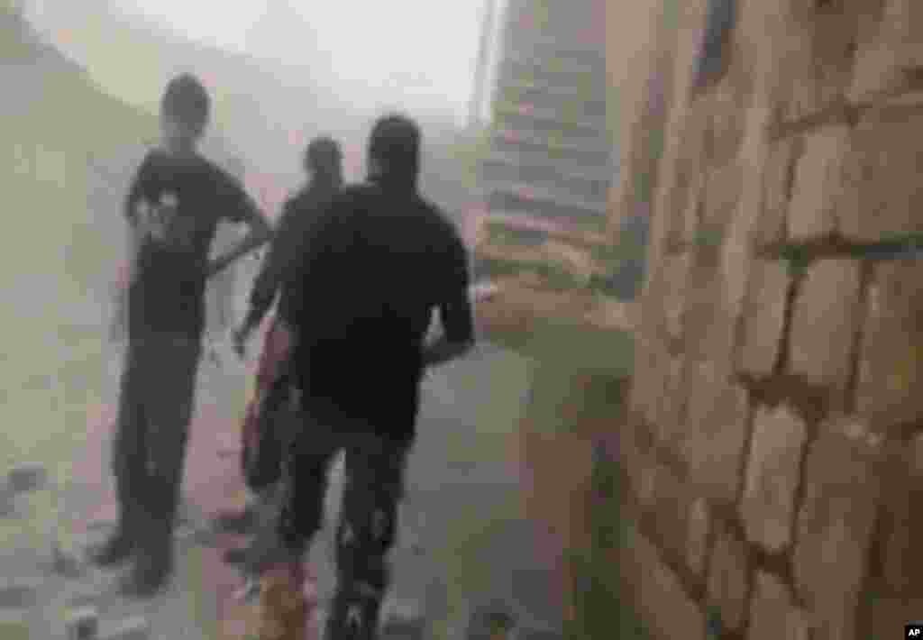 This image made from video provided by Shaam News Network (SNN) and accessed by the Associated Press on Tuesday, September 4, 2012 purports to show people walking through rubble after shelling in Idlib, Syria.