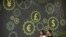 FILE - People walk past a mural on a bank showing symbols for American, Chinese and other world currencies in Beijing, July 7, 2018.