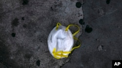 A face mask is discarded on a sidewalk during the coronavirus outbreak in Los Angeles, May 21, 2020. 