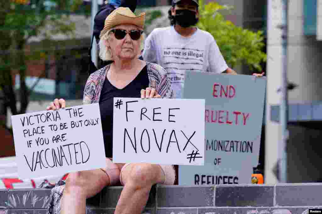 A protester holds signs outside the Park Hotel, where Serbian tennis player Novak Djokovic is believed to be held, in Melbourne, Australia.&nbsp;Novak Djokovic faced at least 72 hours holed up in a Melbourne hotel for immigration detainees after he was denied entry into Australia amid a political firestorm over his&nbsp;medical exemption&nbsp;from COVID-19 vaccination requirements.