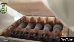 In this screen grab from a video posted to You Tube by Syrian activists, rebels who claim to have captured a government arm depot show crates rockets and other arms. 