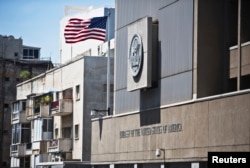 FILE - A flag flutters outside the U.S. Embassy in Tel Aviv, Israel, August 4, 2013. Bending to pressures, U.S. President Donald Trump has retreated from a campaign pledge to move the embassy from Tel Aviv to Jerusalem.