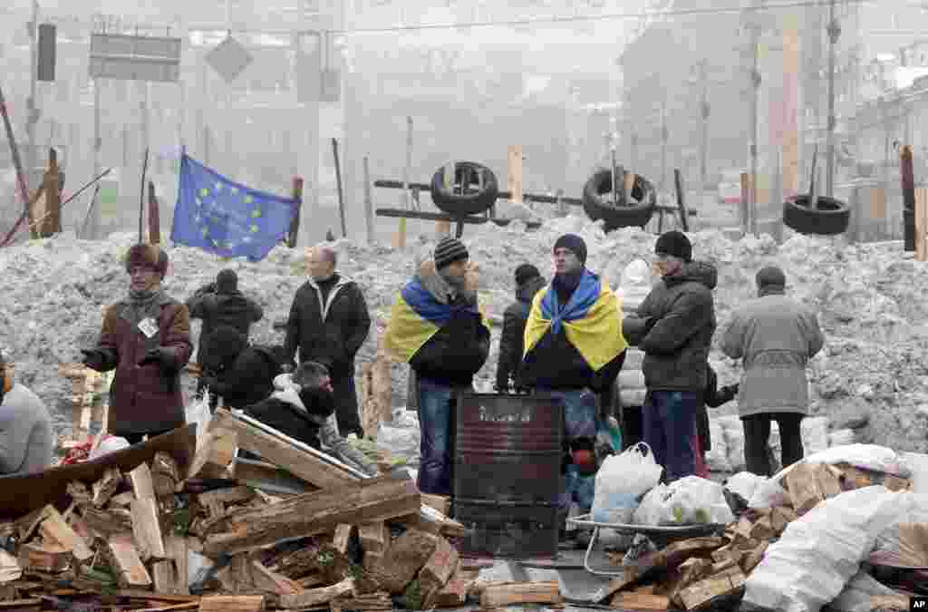 Pro-European Union activists warm themselves near a bonfire and guard barricades on the main street Khreschatyk in Kyiv, Dec. 12, 2013. 