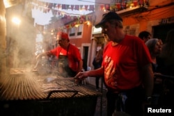 A man grills sardines in the Bica neighborhood in Lisbon, Portugal, June 14, 2018.