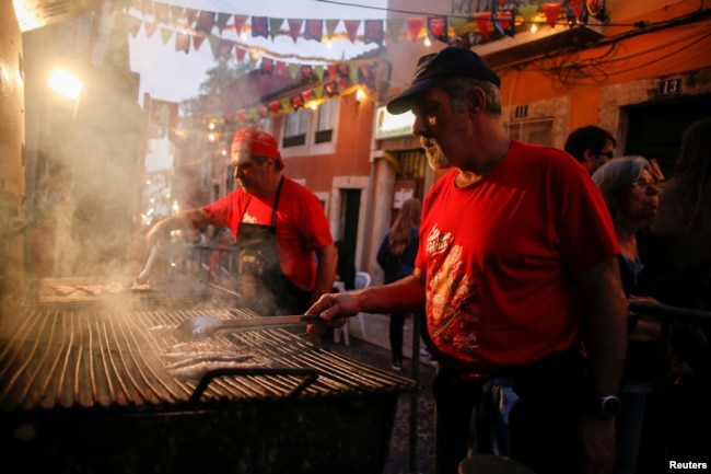 A man grills sardines in the Bica neighborhood in Lisbon, Portugal, June 14, 2018.